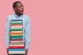 Studio shot of stupefied dark skinned black male professor, holds many books neatly arranged, prepares for seminar or Royalty Free Stock Photo