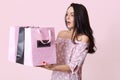 Studio shot of surprised brunette young lady has bated breath, holds many bags, returns from shop with many purchases, dressed in