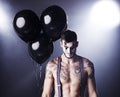 Sinister. Studio shot of a tattooed man with clown makeup on. Royalty Free Stock Photo