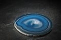 Round blue agate lying on a black plate