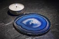 Blue agate slice lying next to candle
