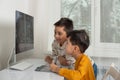 Boys enthusiastically draw on a computer using a tablet