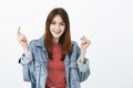 Studio shot of upbeat good-looking girl with brown hair, raising hands and smiling broadly after successful interview