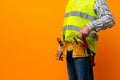 Studio shot of unknown handyman with hands on waist and tool belt with construction tools Royalty Free Stock Photo