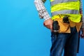 Studio shot of unknown handyman with hands on waist and tool belt with construction tools Royalty Free Stock Photo