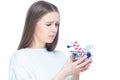 Studio shot of upset disappointed girl holding in her hands a small shopping cart full of expensive pills and medicine Royalty Free Stock Photo