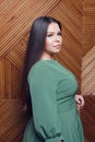 Studio shot of voluptuous woman posing in green dress over white background