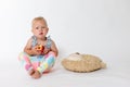 Whole figure of angry toddler girl sitting and holding red apple Royalty Free Stock Photo