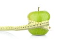 Studio shot of whole green healthy apple with tape measure