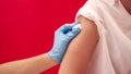 Studio Shot Of Woman Having Arm Swabbed Before Injection Or Vaccination Against Red Background Royalty Free Stock Photo