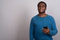 Young African man using mobile phone against gray background Royalty Free Stock Photo