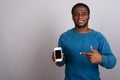 Young African man using mobile phone against gray background Royalty Free Stock Photo