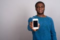 Young African man using mobile phone against gray background Royalty Free Stock Photo