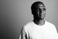 Young African man wearing white shirt and eyeglasses against gray background Royalty Free Stock Photo