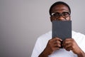 Young African man wearing white shirt and eyeglasses against gra Royalty Free Stock Photo