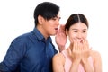 Studio shot of young Asian couple with man whispering to woman l Royalty Free Stock Photo