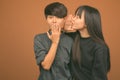 Young Asian lesbian couple together and in love against brown background Royalty Free Stock Photo