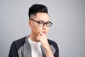 Studio shot of young Asian man thinking while wearing eyeglasses Royalty Free Stock Photo