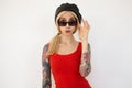 Studio shot of young attractive tattooed blonde woman with ponytail hairstyle looking surprisedly at camera while posing over Royalty Free Stock Photo