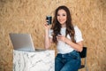 Studio shot of a young beautiful smiling student with dark wavy hair sitting on isolated background, looking at camera Royalty Free Stock Photo