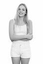 Studio shot of young happy teenage girl smiling while standing with arms crossed Royalty Free Stock Photo