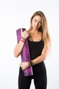 Studio shot of young beautiful teenage girl holding yoga mat and posing ready for gym Royalty Free Stock Photo