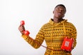 Studio shot of young black African man holding old telephone whi Royalty Free Stock Photo