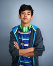 That kids got a ton of confidence. Studio shot of a young boy looking serious with headphones around his neck. Royalty Free Stock Photo