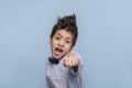 Studio shot of a young boy reading to fend for himself, his fist is ready for battle on against blue background with copy space