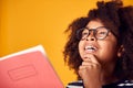 Studio Shot Of Young Boy Studying School Exercise Book Wearing Glasses Against Yellow Background Royalty Free Stock Photo