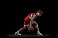 Full-length studio shot of young boy, teenager, basketball player in motion, training isolated over black background Royalty Free Stock Photo