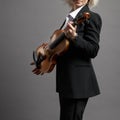 Young woman violinist in a black male suit with a violin Royalty Free Stock Photo