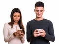 Studio shot of young couple using mobile phone together Royalty Free Stock Photo