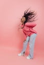 Studio shot of young excited girl with afro hairdo in casual style outfit having fun isolated on pink background Royalty Free Stock Photo