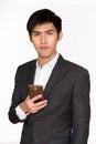 Studio shot of young handsome Asian businessman holding mobile phone isolated against white background Royalty Free Stock Photo