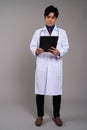 Full length portrait of young Asian man doctor reading clipboard Royalty Free Stock Photo