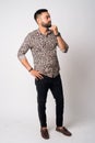 Full body shot of young bearded Indian man thinking Royalty Free Stock Photo