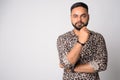 Portrait of young handsome bearded Indian man thinking Royalty Free Stock Photo