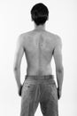 Studio shot of back view of young man standing shirtless against white background