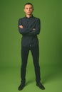 Studio shot of young handsome businessman against green background Royalty Free Stock Photo