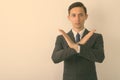 Studio shot of young handsome businessman showing stop hand gesture with both arms against white background Royalty Free Stock Photo