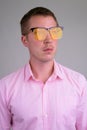 Face of cool young handsome businessman thinking with yellow sunglasses Royalty Free Stock Photo