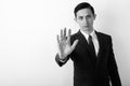 Studio shot of young handsome businessman showing stop hand sign against white background Royalty Free Stock Photo