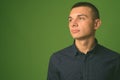 Studio shot of young handsome businessman against green background Royalty Free Stock Photo