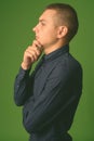Studio shot of young handsome businessman against green background Royalty Free Stock Photo