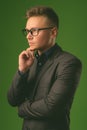 Studio shot of young handsome businessman against green background Royalty Free Stock Photo