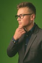 Studio shot of young handsome businessman against green background Royalty Free Stock Photo