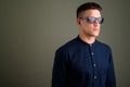 Young handsome businessman wearing sunglasses against colored ba Royalty Free Stock Photo