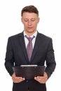 Studio shot of young handsome Caucasian businessman reading clip Royalty Free Stock Photo