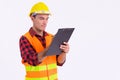 Young handsome Hispanic man construction worker writing on clipboard Royalty Free Stock Photo